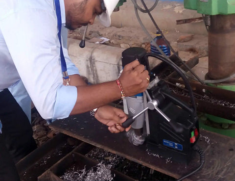 User operating a German Made Portable Magnetic Drill Press With Dual Speed Controls And A Beefy 9.5 Amp Motor That Smashes Through Heavy Steel Plate Jobsite Ready Compact Frame Saves Your Lower Back From Taking A Beating.