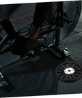 Upgrade Your Home Gym With A Dope Heavy Duty Exercise Bike Belt Pulley Disc shown beside stationary bike on gym floor