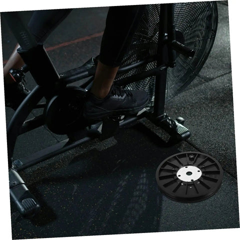 Upgrade Your Home Gym With A Dope Heavy Duty Exercise Bike Belt Pulley Disc shown beside stationary bike on gym floor