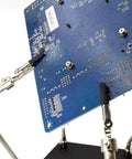 Helping Hand Soldering Third Hand Tool With Flexible Arms holding PCB board for electronic repair on metal base