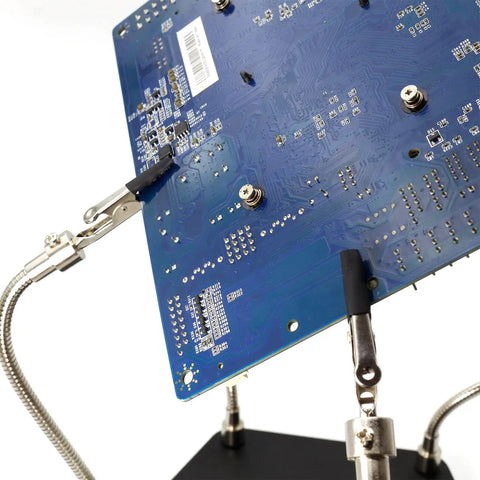 Helping Hand Soldering Third Hand Tool With Flexible Arms holding PCB board for electronic repair on metal base