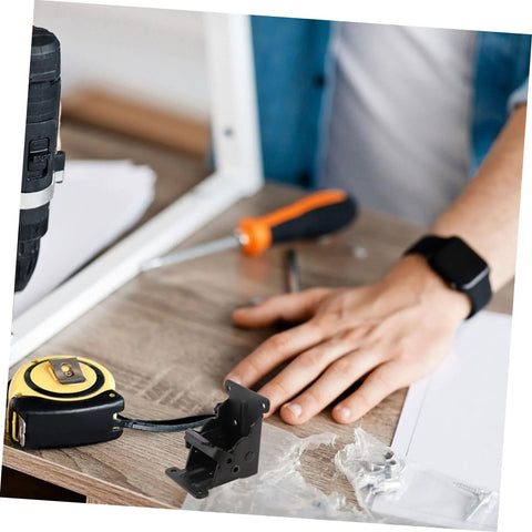 Veemoon two-pack folding hinges for table legs, black metal, shown with tape measure and screwdriver on wood surface.