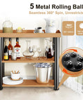 Wooden bar cart with drinks and dishes on two shelves, featuring a close-up of metal rolling ball casters for 360-degree swivel.