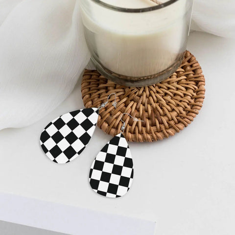 Black And White Checkerboard Teardrop Leather Earrings For Women, Faux PVC Silver Plated Hooks on a woven placemat.