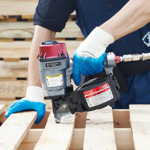Person using CN55 15 Degree Siding Nailer Coil Type for 1 Inch to 2 and One Quarter Inch Nails on wooden pallet.