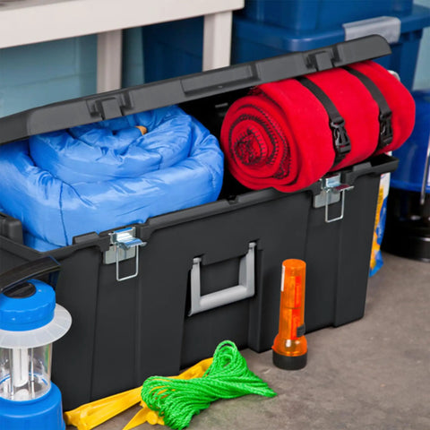 Flex Your Storage Game With Heavy Duty Plastic Footlocker Rolling Bin With Wheels And Handle, Stackable Tote Featuring Secure Latching Lid For Basements Dorms And Shared Spaces, Smooth Operator Hauler Chest In Black storing blue and red blankets with additional gear.