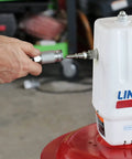 Hand attaching hose to Lincoln 917 Pro Grade 50 To 1 Pneumatic Grease Pump for 120 lb drums, showing control valve and branding.
