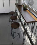 Black Thickened Hairpin Table Legs With Adjustable Height supporting a wooden table on a balcony with three stools.