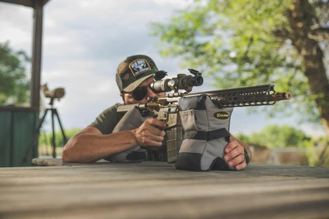 Man using Tactical DeadShot Front And Rear Rifle Rest Combo Filled And Range Ready Adjustable Height For Rifles Heavy Duty Ballistic Nylon