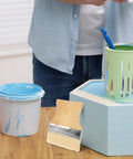 3 Piece Flat Paddle Paint Brush Set With Yang Wood Handles, Natural Bristle Wood Stain Brushes next to green and blue paint cans