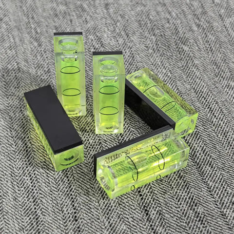 Top Tier 5 Piece Set Of Mini Magnetic Bubble Levels stacked on fabric, featuring green acrylic shell and adhesive backs.