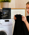 Person using Black Fabric Dye Sheets 10 Pack That Restores Faded Clothes To Rich Black In Every Wash next to washing machine