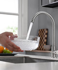 A Total Game Changer For Your Modern Kitchen Or Home Bar With This Dependable Cold Water Only Faucet Finished In Smooth Brushed Nickel and Built Darn Tough From Pure Food Grade 304 Stainless Steel pouring water into a bowl.
