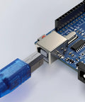 Close-up of an Arduino Compatible ATmega328P Microcontroller Board with USB cable connected, showing digital I/O pins.