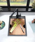 15 Inch Drop-In Bar Sink Workstation With Solid Wood Cutting Board, 16 Gauge Stainless Steel Single Bowl, Outdoor RV Kitchen Prep Sink For Small Spaces, Durable Stainless Bar Basin With Prep Surface in use with celery and knife on board.