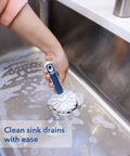 Person using Heavy Duty Sink And Dish Scrub Brush With Safe Bristles on a soapy kitchen sink, effectively cleaning drains.