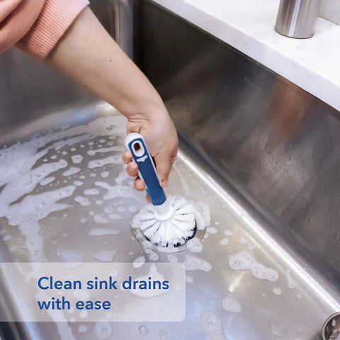 Person using Heavy Duty Sink And Dish Scrub Brush With Safe Bristles on a soapy kitchen sink, effectively cleaning drains.