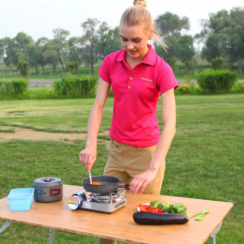 Woman using durable camping cookware set with nonstick hard anodized aluminum pots and pans mess kit for outdoor cooking