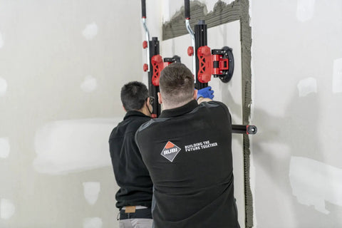 Workers installing a heavy duty slab conveyor for transporting ceramic sheets and large format tiles, built for tough jobs and everyday worksites.