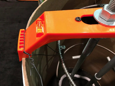 Close-up of Orange 24 Inch Bolt Template Tool For Nested 24 And 25 Inch Tubes with Level and Four Arm Design on concrete tube.