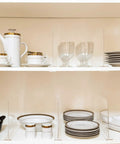 8 Pack Acrylic Shelf Dividers for Closet Organization holding dishes and glasses, clear adjustable storage spacers on wooden shelf.