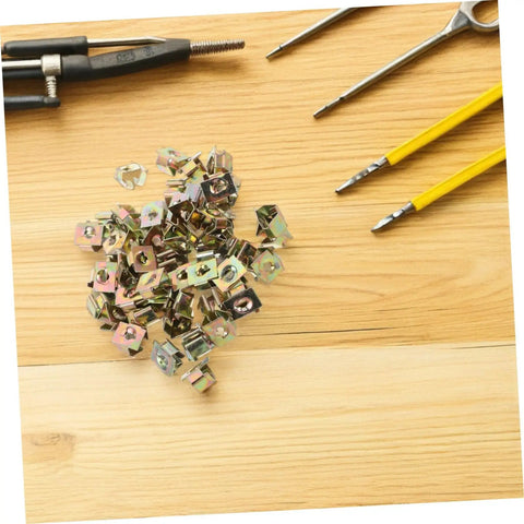 50 Pack Of Straight Up Solid Iron Captive Nut Fasteners With Top Shelf License Plate Screw Retainer Clips on wood surface.