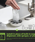 Hand using Straight Fire Stainless Steel Glass Rinser for quick rinse of baby bottle at kitchen sink, sleek design.