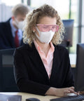 Anti Fog Safety Goggles For Men And Women With Blue Light Blocking UV Protection Dust Resistant Coating Scratch Resistant Lenses Pink Frame Unisex Eyewear For Work Home Or Travel Clear Vision And All Day Comfort worn by a person working at a computer