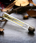 Dimmable T10 LED Filament Tubular Bulbs 4000K Daylight White, 6W Edison Style, 60W Equivalent, on wooden surface with leaves