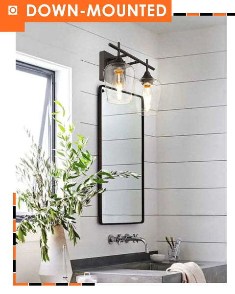 Oil Rubbed Bronze Two Light Bathroom Vanity Fixture Over Mirror With Clear Glass Shades in modern bathroom setting