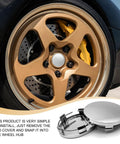 4 Pack Silver Car Wheel Center Hub Covers, 60 mm Outer Diameter And 50 mm Inner Diameter, Snap-In Rim Caps displayed with car wheel