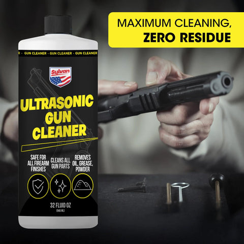 Front view of a plastic Ultrasonic Gun Cleaner bottle (32 oz) with black label and yellow text; gun parts in background.