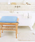 Blue shower chair cushion for elderly and disabled on bamboo bench in bathroom, breathable mesh foam, non slip comfort, easy to clean.