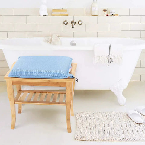 Blue shower chair cushion for elderly and disabled on bamboo bench in bathroom, breathable mesh foam, non slip comfort, easy to clean.