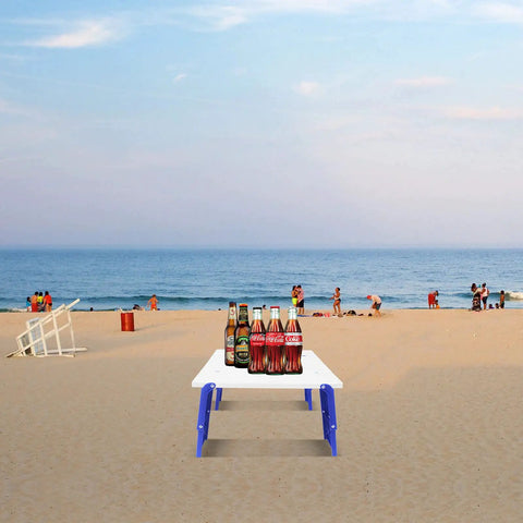 Grab-And-Go Portable Folding Beach Table For Sand With Carry Bag Ultra Lightweight Outdoor Side Table For Camping Picnic And BBQ Adjustable Height Blue on a beach with drinks