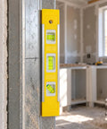 Spirit Level, Aluminum Alloy with yellow casing positioned on a metal frame for accurate leveling in a work area.