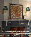 EIDISUNY Battery Operated Wall Sconces with adjustable brightness next to art and fireplace in living room.
