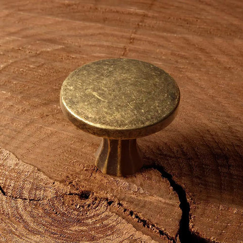 Antique brass cabinet knob in zinc alloy, showing detailed texture, part of Six Pack Antique Brass Cabinet Knobs Zinc Alloy For Kitchen Drawers 2202 GT DAN Includes Two Metric M4 Screws Easy Install Durable Solid Hardware For Cabinets And Dressers.