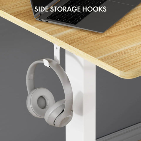 FLEXISPOT En1 Electric Standing Desk with side storage hooks holding gray headphones, showcasing functionality and design.