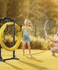 Image of a black garden hose reel holder with four foot design keeping a yellow hose tidy in a sunny yard.