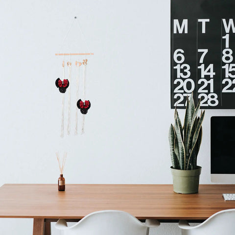 Modern minimalist workspace with a calendar, potted plant, and decorative wall hanging.