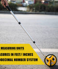 Person using Measuring Wheel 6 Inch Distance Meter For DIY And Pro Builders Rugged Telescoping Handle Mechanical One Button Reset Starting Point Arrow Cloth Carrying Bag Readout Up To 10000 Ft on a road