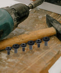Socket Cap Bolts Set In Black Iron With Round Button Heads And Internal Socket Design For Quick Tightening And Rock Solid Connections In Furniture And Hardware Projects 20 Pieces shown with drill and hammer.