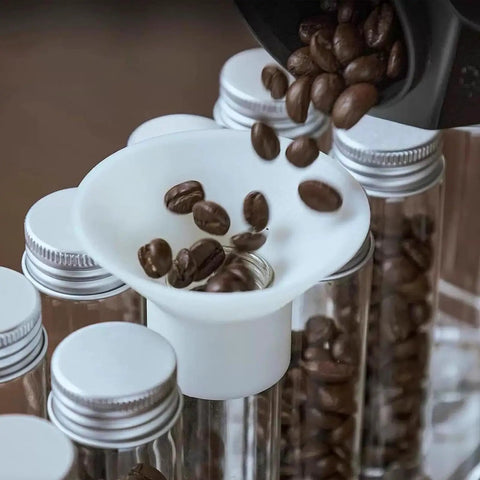 14 Piece Single Dose Coffee Bean Storage Tubes With Airtight One Way Valve And Heavy Duty Metal Stand pouring beans into tube.