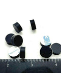 One Half Inch Round Silicone Rubber Bumper Feet Three Sixteenths Of An Inch Thick Adhesive Backed Spacer Pads scattered on surface