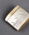 Solid Brass Habaki Collar Clip for Katana Blade on textured surface, showing intricate detailing and durable craft