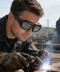 Man using Kickass Auto Darkening Welding Goggles Solar Powered Wraparound Safety Eyewear while welding with sparks flying.
