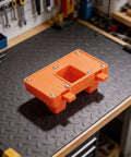 No Hands Free Electric Wire Welding Fixture With Adjustable Clamps For Precision Alignment Heat Resistant Soldering Helper Tool in vibrant orange on a workbench.