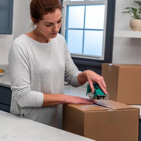 Woman sealing a box with EZ Start Clear Packing Tape Refills For Shipping Moving And Storage 6 Rolls 1.88 Inch By 55 Yards