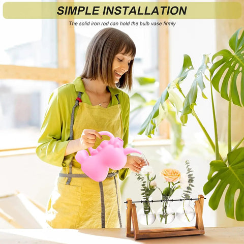 Woman watering terrarium plant display with wooden stand and glass bulb vases, vintage metal swivel holder for desktop decor